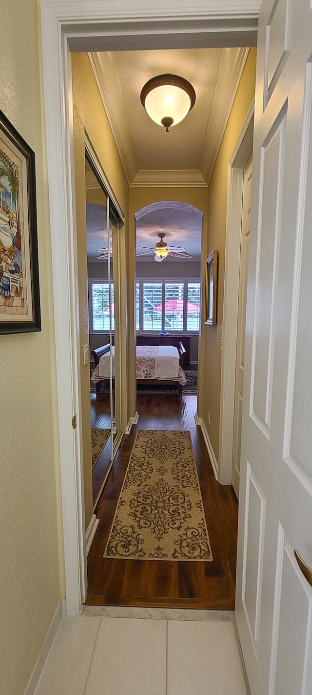 bedroom with ceiling fan, crown molding, and dark wood-type flooring