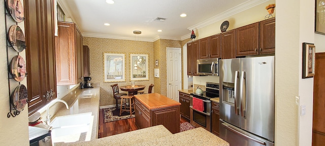 kitchen with a center island, stainless steel appliances, light stone counters, dark hardwood / wood-style floors, and crown molding