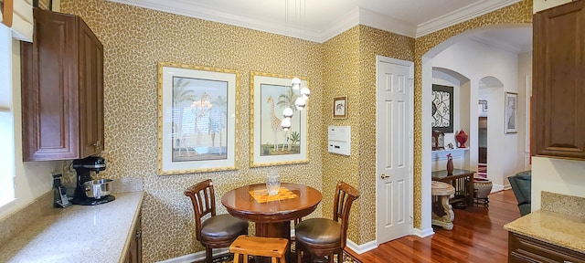 dining room with crown molding and dark hardwood / wood-style floors