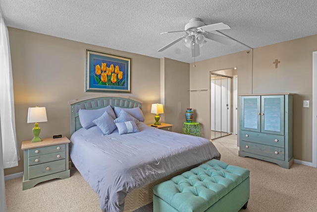 carpeted bedroom with ceiling fan, a textured ceiling, and a closet