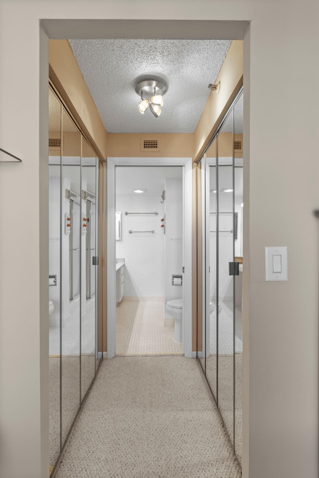 corridor featuring carpet floors and a textured ceiling