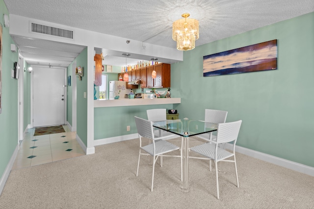 dining area featuring light carpet and a textured ceiling