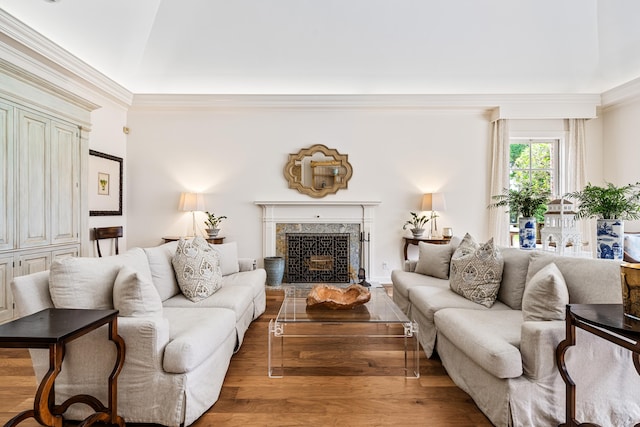 living room with ornamental molding, a premium fireplace, and hardwood / wood-style flooring