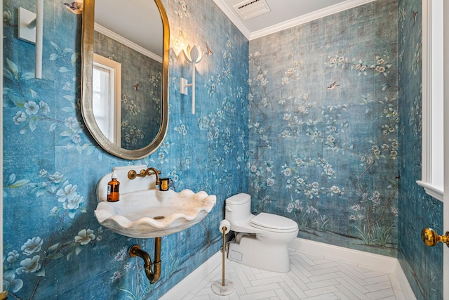 bathroom featuring ornamental molding, sink, and toilet