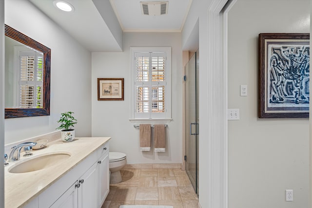 bathroom with toilet, vanity, a shower with door, and crown molding