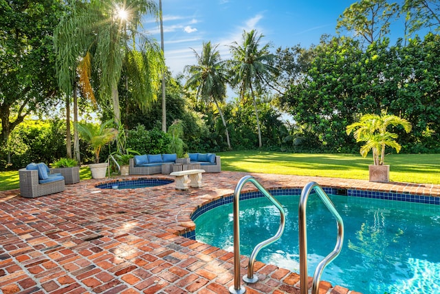 view of pool with a jacuzzi, outdoor lounge area, a lawn, and a patio area