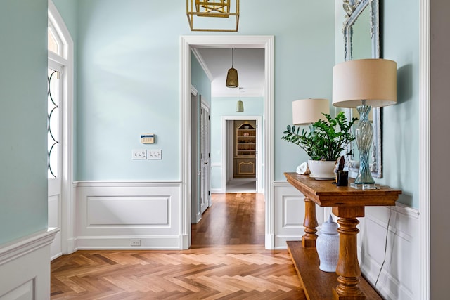 entrance foyer featuring light parquet flooring and crown molding