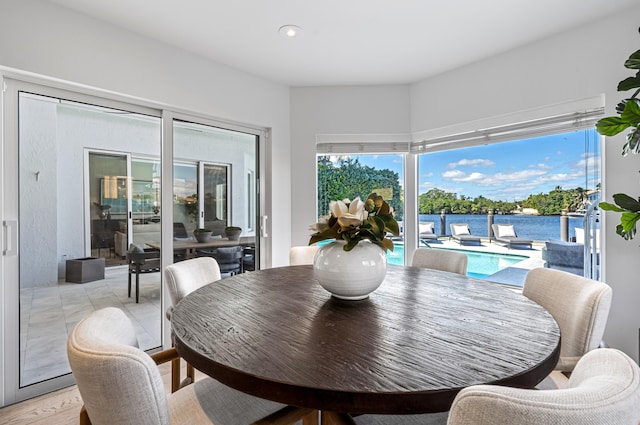 dining space featuring a water view and light hardwood / wood-style floors