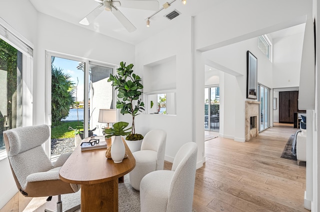 1026 Seasage Dr, Delray Beach, FL 33483 - dining area featuring a high end fireplace, light wood finished floors, baseboards, ceiling fan, and a high ceiling