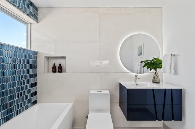 bathroom with tile walls, vanity, toilet, and a washtub