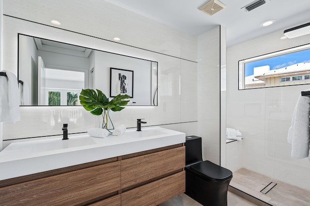 bathroom featuring tile walls, vanity, toilet, and tiled shower