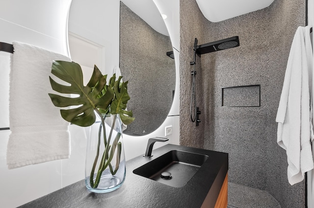 bathroom featuring vanity and tiled shower