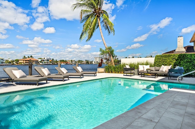 view of swimming pool with a water view, an outdoor living space, and a patio area