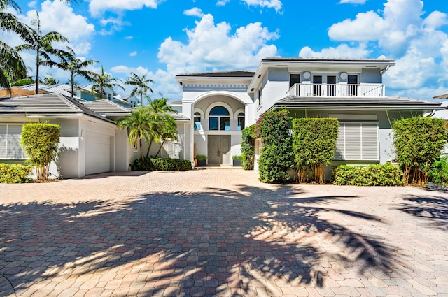 1026 Seasage Dr, Delray Beach, FL 33483 - mediterranean / spanish home featuring a balcony, stucco siding, a garage, decorative driveway, and a tiled roof
