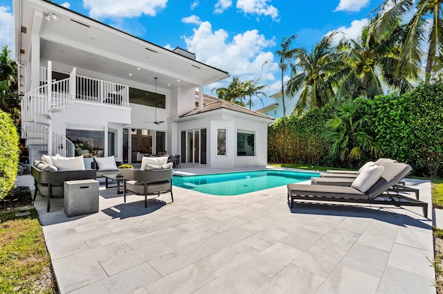 1026 Seasage Dr, Delray Beach, FL 33483 - rear view of property featuring outdoor lounge area, stairs, a balcony, a patio area, and an outdoor pool