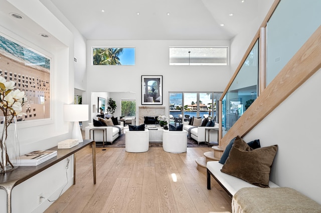 1026 Seasage Dr, Delray Beach, FL 33483 - living area featuring light wood finished floors, a towering ceiling, a fireplace, and recessed lighting