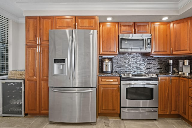 kitchen with tasteful backsplash, beverage cooler, crown molding, dark stone countertops, and appliances with stainless steel finishes