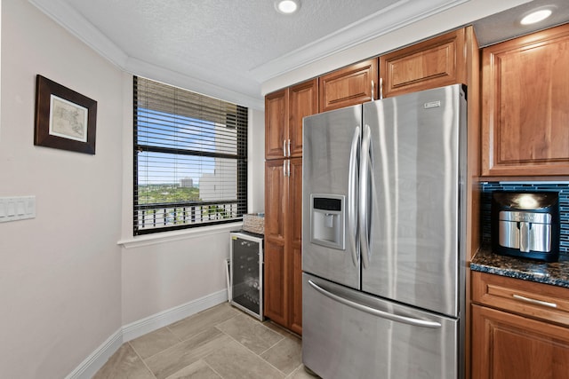 kitchen featuring stainless steel fridge, beverage cooler, a textured ceiling, dark stone countertops, and crown molding