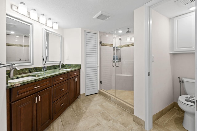 bathroom featuring a textured ceiling, walk in shower, vanity, and toilet