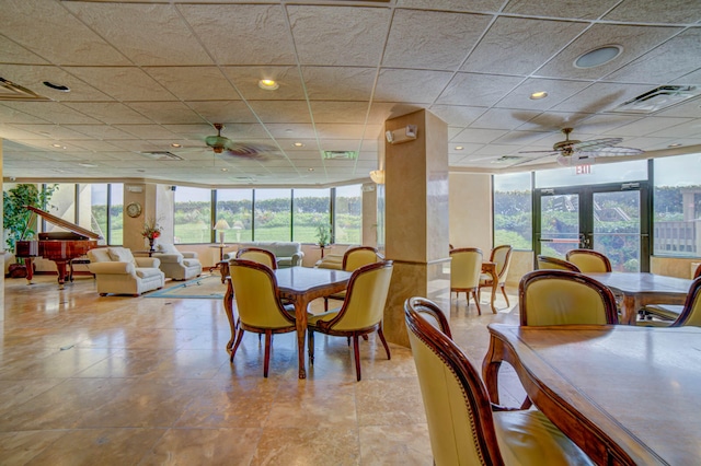 dining space featuring a drop ceiling, french doors, floor to ceiling windows, and ceiling fan