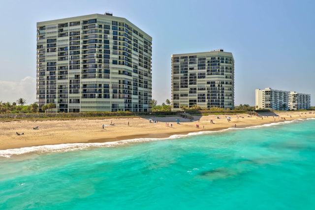 view of swimming pool featuring a water view and a beach view