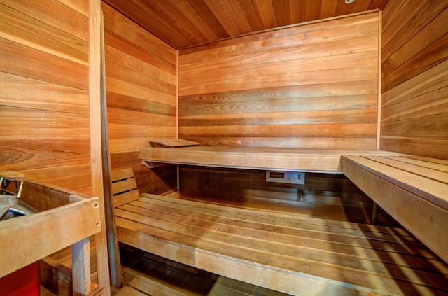 view of sauna featuring tile patterned flooring, wood walls, and wooden ceiling