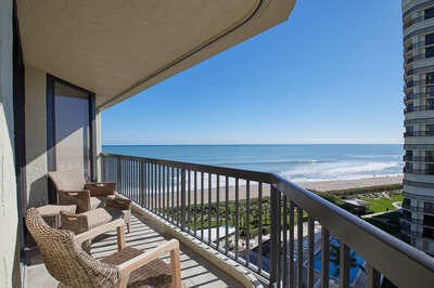 balcony featuring a water view and a view of the beach