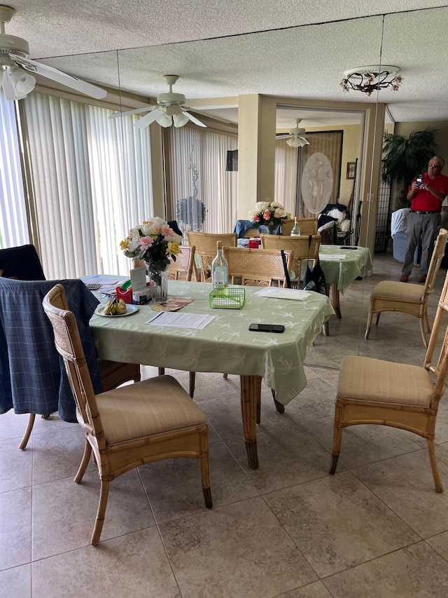 dining area featuring a textured ceiling, ceiling fan, and light tile patterned floors