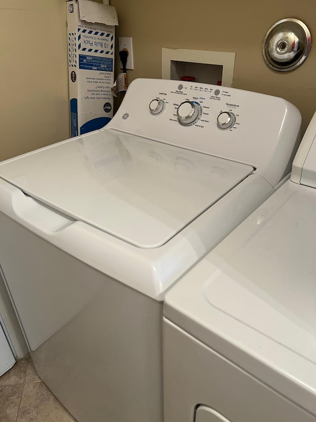 laundry area featuring light tile patterned floors and separate washer and dryer