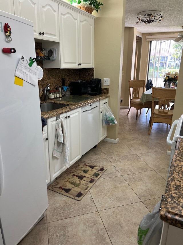 kitchen featuring decorative backsplash, white cabinets, a textured ceiling, sink, and white appliances