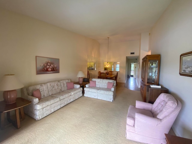 carpeted living room featuring a chandelier