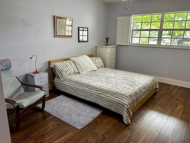 bedroom with dark hardwood / wood-style flooring