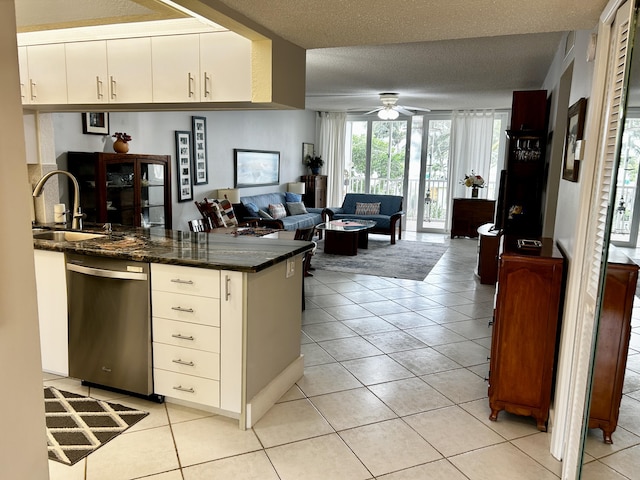 kitchen featuring light tile patterned floors, sink, dishwasher, white cabinets, and a textured ceiling