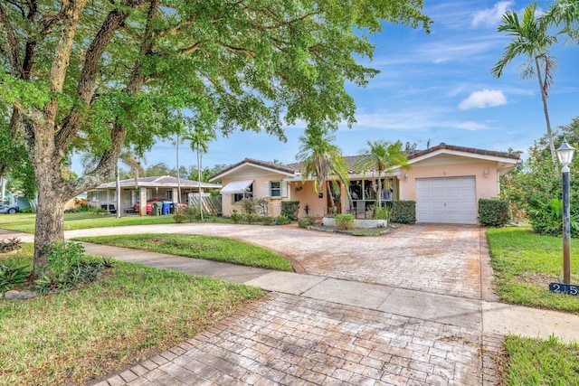 single story home featuring a garage and a front lawn