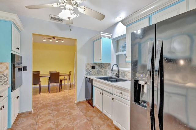 kitchen featuring sink, appliances with stainless steel finishes, tasteful backsplash, light tile patterned flooring, and white cabinetry