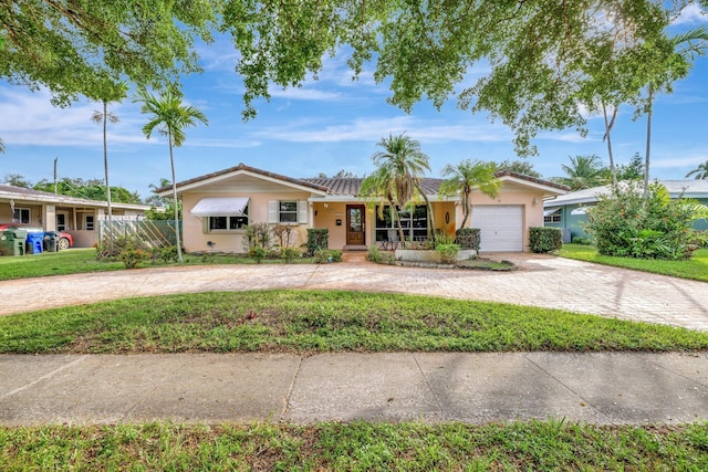 ranch-style house with a garage and a front lawn