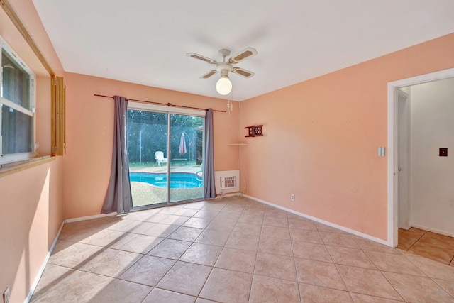 tiled spare room featuring ceiling fan