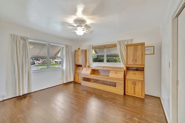 unfurnished living room with ceiling fan and hardwood / wood-style flooring