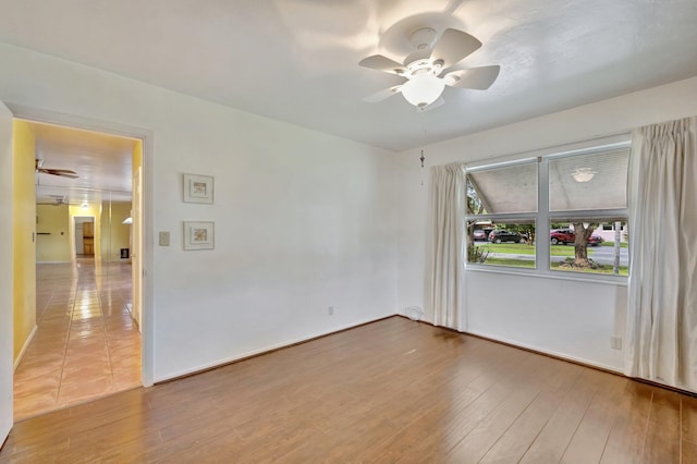 empty room with hardwood / wood-style floors and ceiling fan