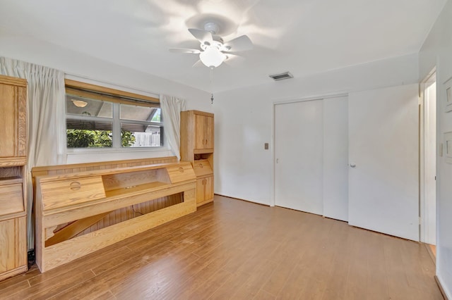 unfurnished living room featuring ceiling fan and wood-type flooring