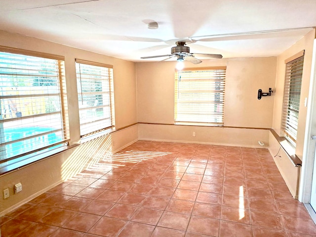 tiled empty room featuring ceiling fan