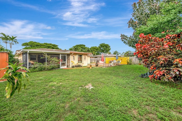 view of yard with a sunroom and a patio area