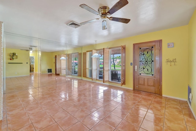 unfurnished living room featuring ceiling fan and light tile patterned flooring