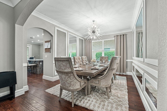 dining space featuring arched walkways, a notable chandelier, wood-type flooring, a textured wall, and ornamental molding