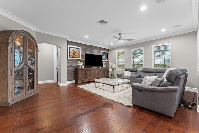 living room with arched walkways, visible vents, baseboards, and hardwood / wood-style flooring