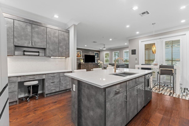 kitchen featuring dark wood-style floors, ornamental molding, a sink, gray cabinetry, and built in desk