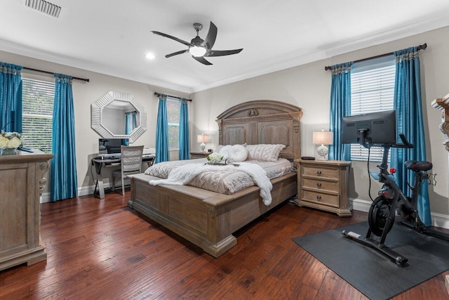 bedroom featuring crown molding, visible vents, a ceiling fan, baseboards, and hardwood / wood-style flooring