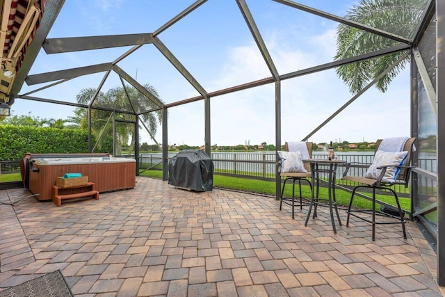 view of patio with glass enclosure, a grill, and a hot tub