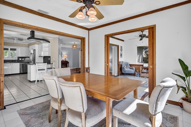 dining area featuring ornamental molding and tile patterned flooring