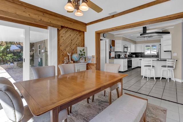 tiled dining room featuring beam ceiling and ceiling fan